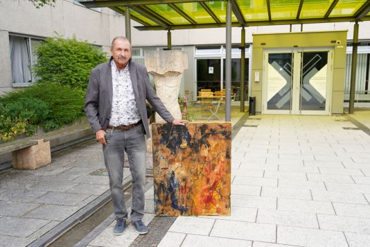 Franz Hlinka mit einem seiner Gemälde vor der Klinik Mallersdorf Neuigkeiten 2025